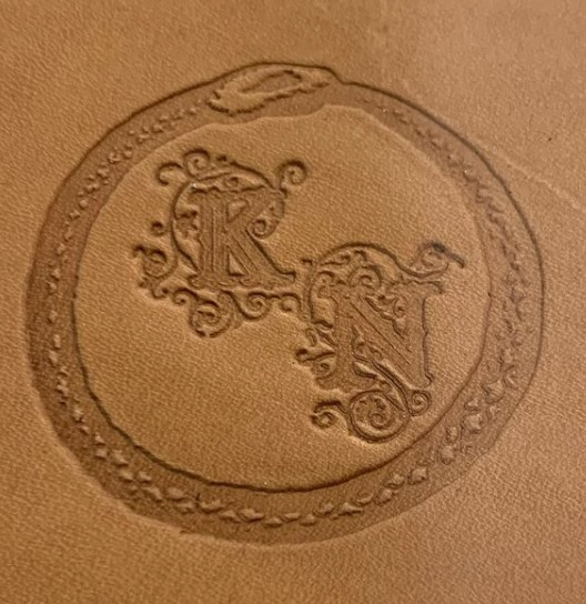 Leather imprinted with decorative initials.