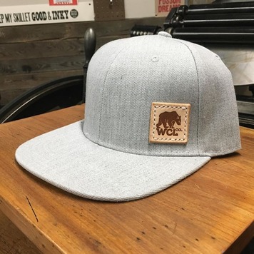 Light blue cap with leather label featuring a branded logo.
