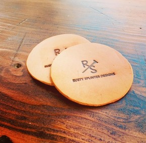 Rustic leather coaster with a branded design.